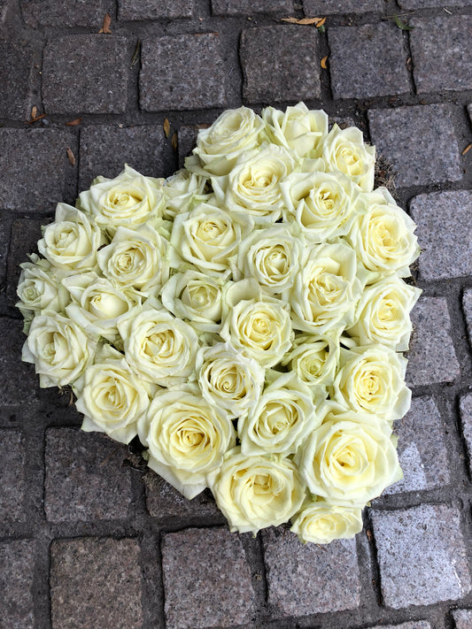 Allerheiligen bloemstuk in vorm van een hart opgevuld met witte rozen