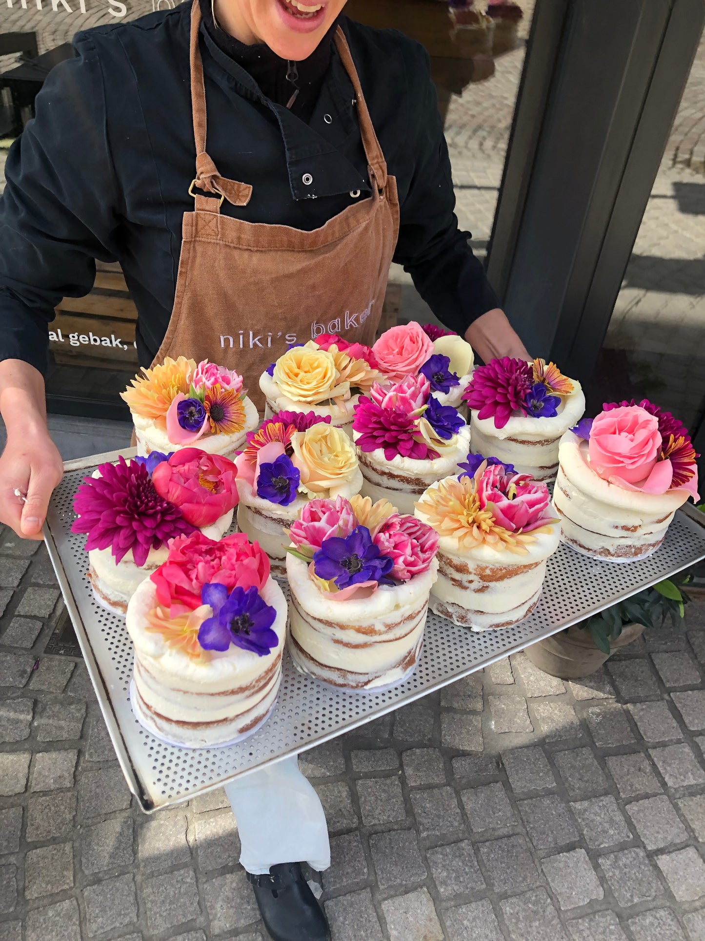 Niki's Bakery showt een plateaux met gebakjes afgewerkt met kleurrijke bloemen als topping