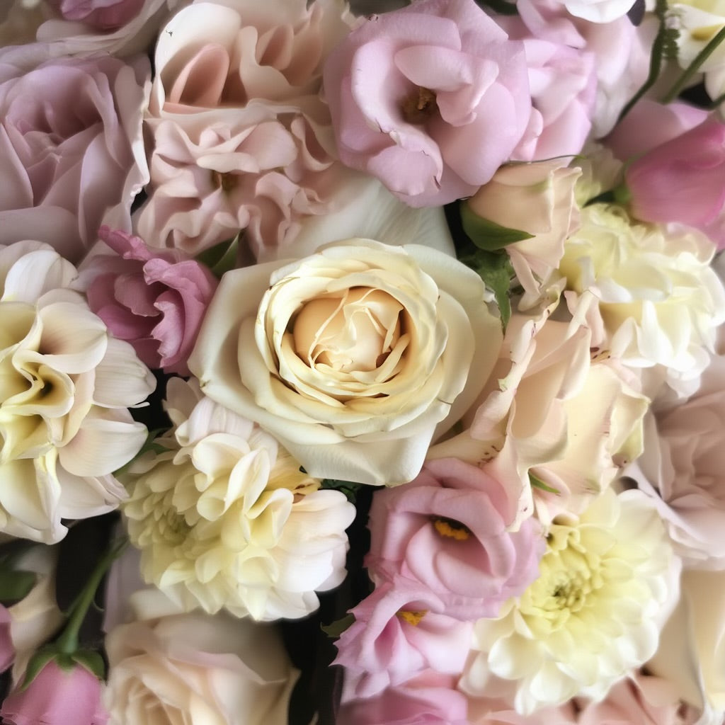 Het bloemstuk van 40 en 60 cm bevat Rozen in crème-wit en antiekroze tinten, Dahlia’s in warme pastelkleuren en Lisianthus met hun delicate, klokvormige bloemblaadjes.