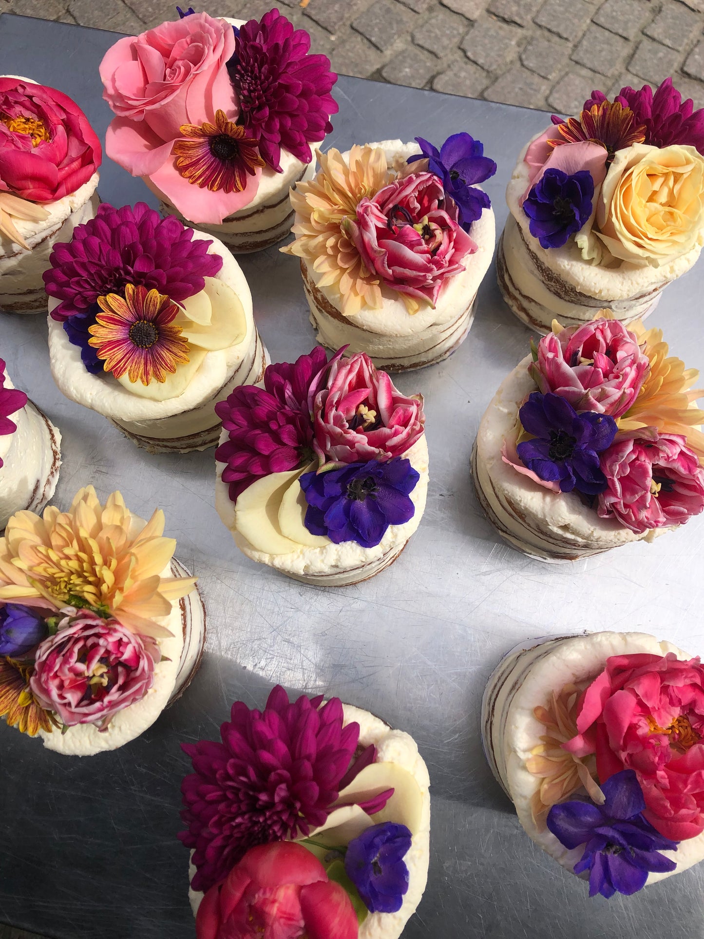 Taarten gedecoreerd met verse bloemen zoals rozen, delphiniums en pioenen