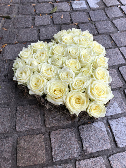Allerheiligen bloemstuk in vorm van een hart opgevuld met witte rozen