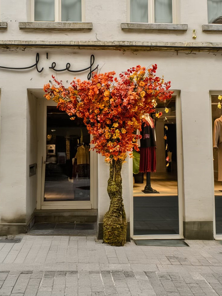 Creatie van boom met kruin vol bloemen in oranjetinten en een stam van mos